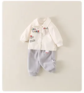 Détail de la veste bébé avec broderie chiot et pantalon de jogging gris assorti