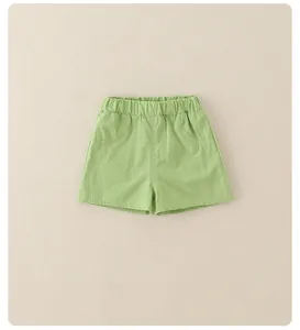 Detail of girls grass green summer shorts featuring elastic high waist and cotton texture