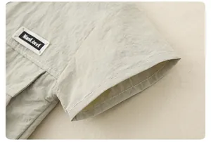 Detail of light green boy shirt with contrast stitching and textured fabric finish