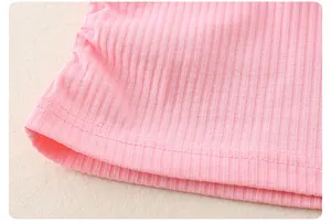 Dettaglio della trama del tessuto a coste rosa e doppie cuciture sulla maglia da bambina
