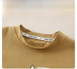 Detailed close-up of khaki cotton knit neckline with clean stitching and decorative tape
