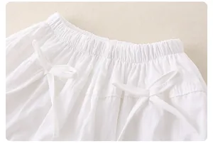 Dettaglio gonna bianca in cotone per bambina con vita elastica e decorazioni a fiocco