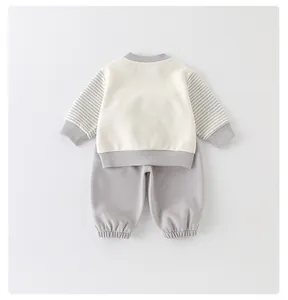 Detail of baby cotton two-piece set featuring striped sleeves and ribbed knit cuffs