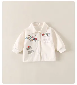 Détail de la veste crème pour garçon avec motif chien mignon et texte porte-bonheur