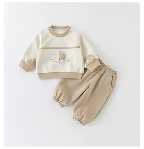 Detailansicht der Baby-Baumwollanzug mit Krokodil-Stickerei auf dem beigen Sweatshirt und Hose