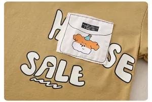 Close-up of cotton kid's T-shirt with bubble lettering and cartoon dog pocket detail