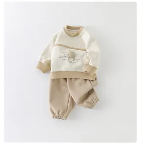 Detail von Baby-Baumwoll-Sweatshirt mit niedlichem Plüsch-Dinosaurier und Stickerei