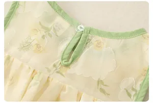 Detail of toddler girl floral top showing sheer fabric, green edging and back button
