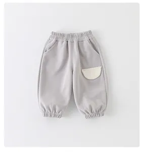Detail of light gray baby joggers with elastic waistband and white stitched pocket
