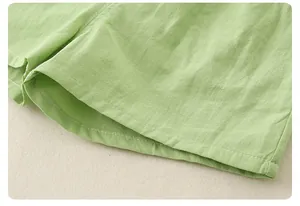 Close-up of light green cotton linen fabric with reinforced double stitching detail