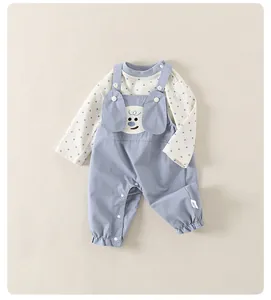 Detail der Baby-Latzhose mit gesticktem Welpen und blauem Polka-Dot-Muster am Oberteil