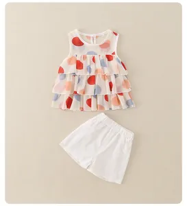 Dettaglio top senza maniche in chiffon a pois colorati e pantaloncini bianchi da bambina