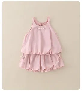 Détail de l'ensemble rose pour fille montrant des nœuds et la texture à ourlet bouffant