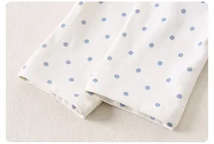Makroaufnahme der Kinderhose mit blauen Punkten auf weichem Baumwollstoff und feiner Naht