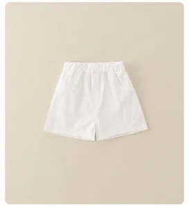 Dettaglio di pantaloncini estivi bianchi per bambine con elastico e tasche laterali