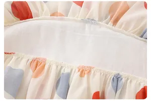 Dettaglio del tessuto in chiffon a pois rossi e blu con delicati bordi a volant