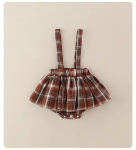 Detailweergave van de rood geruite baby-overaljurk met handige drukknopen aan de onderkant