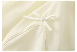Détail du haut d'été crème montrant la texture du tissu et le nœud à cordon de serrage