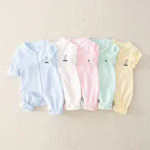 Detail of five-pack newborn cotton bodysuits with sailboat embroidery in pastel colors