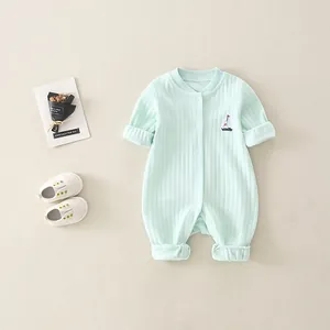 Close-up of mint green ribbed cotton baby romper with sailboat embroidery detail