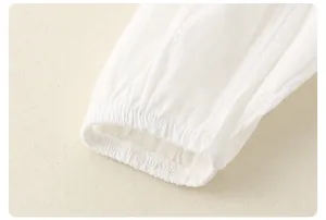 Detailopname van witte getextureerde blousemouw met elastische ruches manchetten