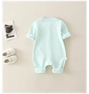 Detail of light green ribbed cotton baby romper with soft knit texture and long sleeves
