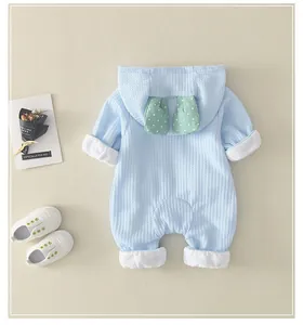 Detail of light blue waffle knit baby romper featuring cute polka dot rabbit ears on the hood