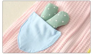 Detail of pink waffle knit baby romper featuring a blue pocket and cactus decoration
