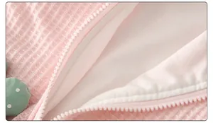 Close-up of baby romper featuring pink waffle fabric and durable white plastic zipper