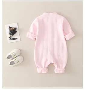 Detailed view of pink long-sleeved newborn cotton romper with textured rib fabric