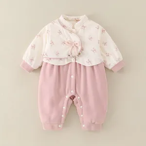 Detail of floral baby down romper with pink bows and convenient snap-button closure
