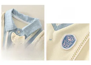 Close-up of yellow knit baby dress with blue striped collar and heart embroidery