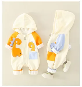 Detail of baby cotton romper featuring cartoon dinosaur patch and ribbed sleeve cuffs