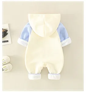 Detail of baby romper featuring hooded design, color-block sleeves and soft cotton texture