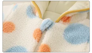 Nahaufnahme des dicken Sherpa-Fleece-Baby-Stramplers mit bunten Punkten und gelbem Futter