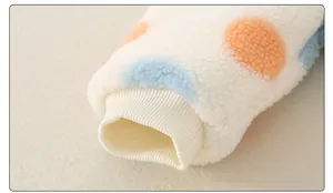 Detail der Lammwollärmel mit bunten Punkten und winddichten Rippbündchen am Babyanzug