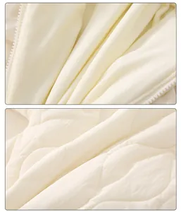 Detail of warm quilted diamond pattern and soft fleece lining on newborn baby romper coat