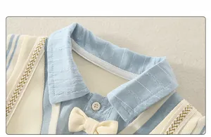 Detail of baby cotton romper with classic polo collar and ivory bow tie decoration