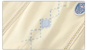 Detail of soft ribbed cotton fabric with embroidered diamonds and woven trim for infants