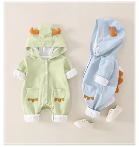 Detail of dinosaur baby rompers with orange horns and cute claw embroidery on pockets