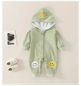 Detail von grünem Baby-Strampler mit Dinosaurier-Kapuze und süßen Smiley-Knieaufnähern