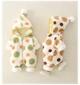Detail der warmen Baby-Winter-Strampler mit Punkten und weichen Pompon-Kapuzen