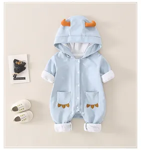 Detail of baby cotton romper with hood, featuring 3D decorative horns and white snap buttons