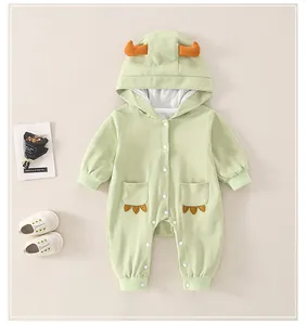Detail of light green baby cotton romper featuring dinosaur hood horns and claw embroidery