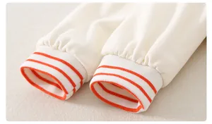 Detail der Baby-Strampler-Manschette mit orangefarbenen Streifen und Baumwollstruktur