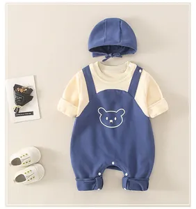 Detail eines Baby-Stramplers aus Baumwolle mit Bärenprint, Druckknöpfen und Mütze