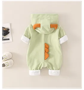 Detail of baby dinosaur romper with orange soft spikes and hooded back design