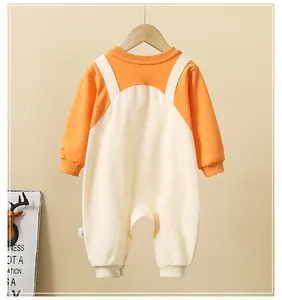 Close-up of orange and beige baby romper with ribbed cuffs and soft cotton texture