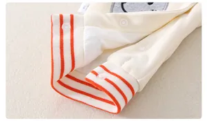 Details von Baby-Baumwoll-Jumpsuit mit orange gestreiften Rippbündchen und Druckknöpfen