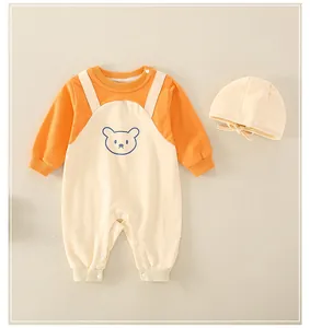 Detail of newborn cotton bear romper set featuring orange contrast sleeves and matching hat